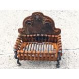 A rectangular cast iron fire basket, the scalloped fireback with scrolled decoration above a slatted