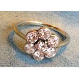 An 18ct gold diamond ring having flowerhead setting with seven diamonds, having raised central