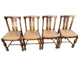 A set of four oak dining chairs with rounded backs above twin splats with applied carving, the