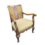 A 1950s mahogany cottage armchair, with twin caned panels to back above a loose cushion seat, the