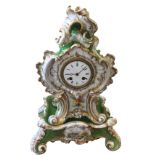 A rococo style French porcelain mantleclock on stand, the case with gilt shell scrolled decoration