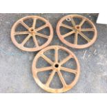 A set of three cast iron wheels with triangular pointed rims, each having seven spokes. (26.5in dia)