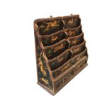 A painted hanging Indian stationary rack with eight scalloped compartments above two panelled