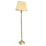 A brass standard lamp with octagonal column on moulded weighted base, fitted with pleated shade. (