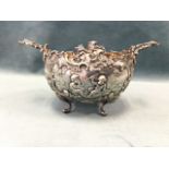 A Victorian silver sucrié embossed with scrolled panels of cherubs & storks, with scrolled handles &