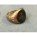 A 15ct gold signet ring set with circular agate intaglio panel of a gryphon above a banner - size H.