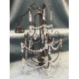 A contemporary hanging wrought iron chandelier, the scrolled frame with tree tiers of swagged