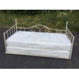 A disassembled painted metal daybed with two wrapped mattresses, the iron frame with spindles and