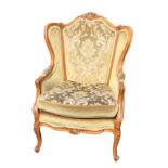 A Louis VI style fauteuil with scroll carved upholstered wing back above a seat with loose