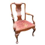 A nineteenth century Queen Anne style walnut armchair with wide shaped splat beneath a scroll carved