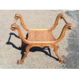 A Georgian style carved walnut stool, the gryphon-head terminals supporting leaf carved turned rails