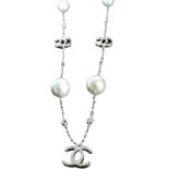 A silver & pearl necklace on fine chain, having eight graduated pearls alternating with interlocking