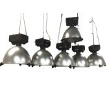 A set of six kettledrum shaped hanging lights with circular glass lenses enclosing interior