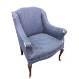 An upholstered armchair with padded back and shaped arms above a sprung upholstered seat, raised