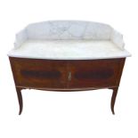 A bowfronted Edwardian marble topped mahogany washstand, the slab with arched back above two doors