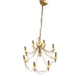 A gilt metal hanging chandelier with eight candlelights mounted as torches with bead swags, the