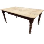 A Victorian pine table with rectangular rounded top on turned tapering legs - telescopic with