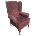 An upholstered wingback armchair with loose cushion above a sprung seat, raised on cabriole legs.