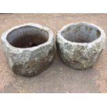 A pair of circular carved granite garden pots with rough-cast edges and pierced interiors. (15in x