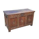 An eighteenth century oak coffer with chisel carved two-piece top above an interior with