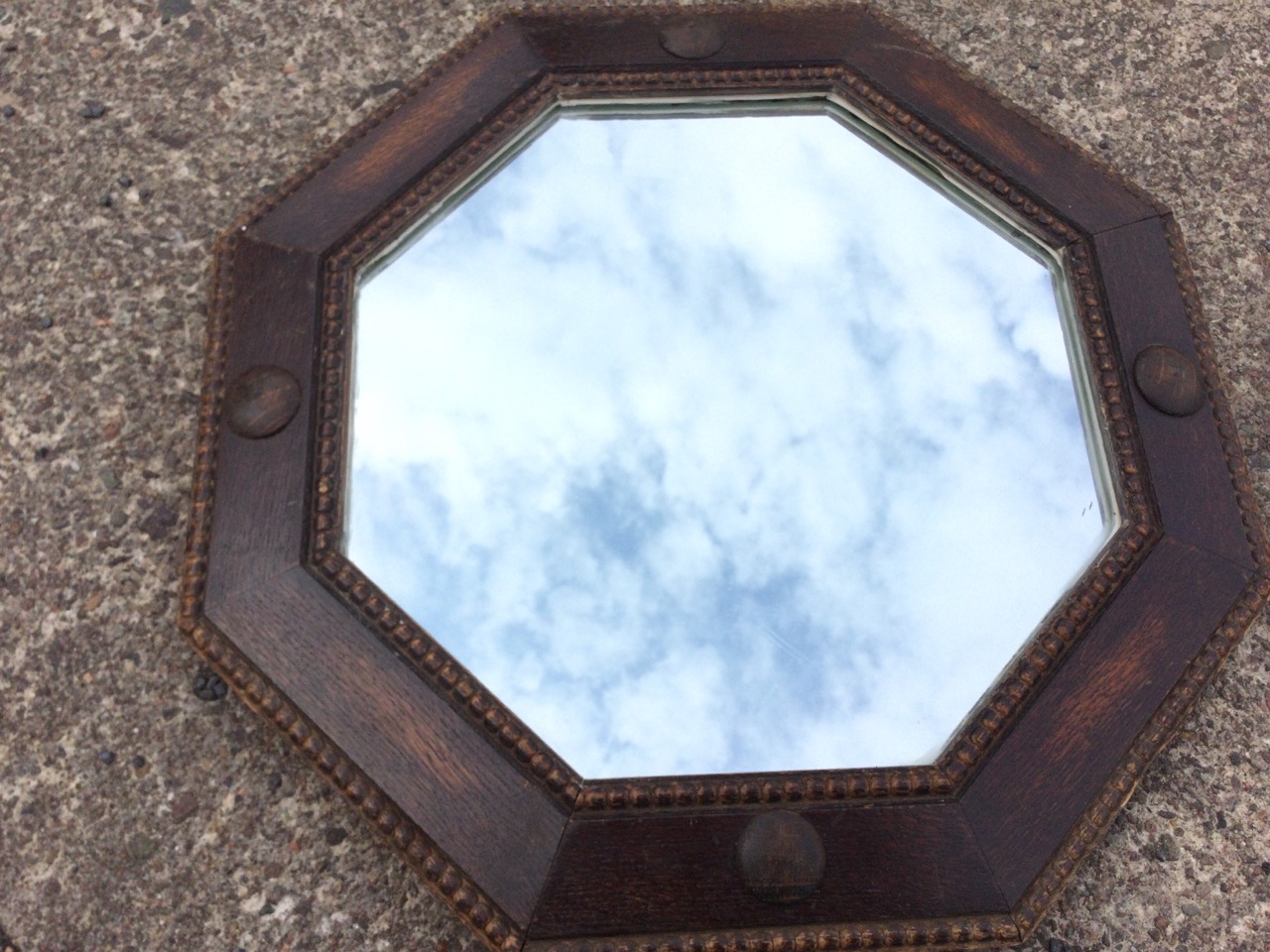 A 1930s octagonal oak mirror in bead moulded angled frame with applied roundels. (21in) - Image 3 of 3