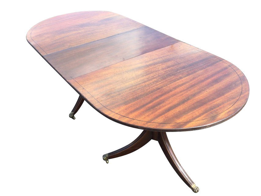 A Georgian style mahogany dining table, the crossbanded top with spare leaf having ebony
