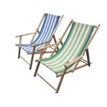 A pair of folding elm deck chairs with platform arms on rectangular legs, having striped canvas