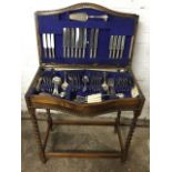 An oak cased canteen of silver plated cutlery, the beaded box on barleytwist legs containing