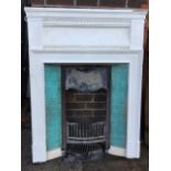An Edwardian cast iron fireplace with moulded dentil cornice above a cushion frieze, the insert with
