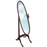 An oval mahogany cheval mirror, the frame on rectangular tapering supports with turned finials,