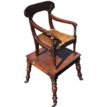 A nineteenth century mahogany childs chair having bar back carved with roundels above arms on ring-