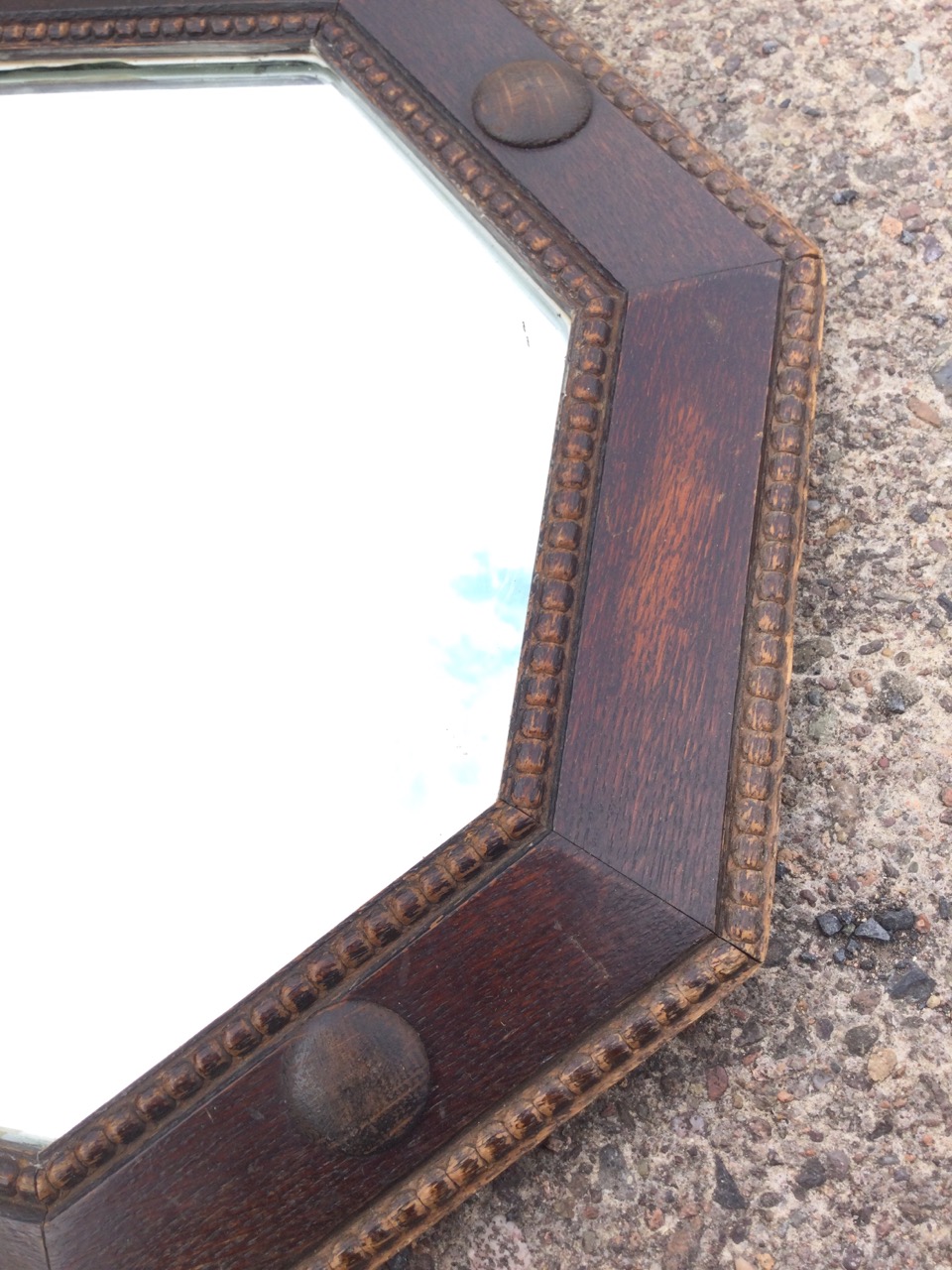 A 1930s octagonal oak mirror in bead moulded angled frame with applied roundels. (21in) - Image 2 of 3