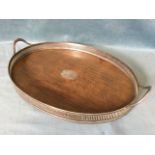 An oval Edwardian oak drinks tray with silver plated pierced gallery and shaped handles. (24.5in)