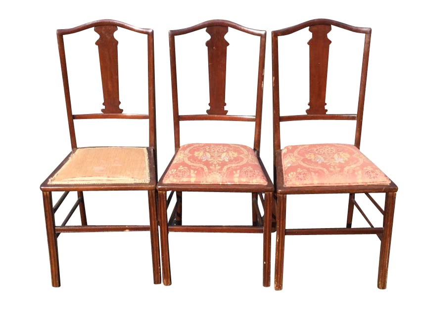 A set of three Edwardian mahogany bedroom chairs having arched backs and shaped splats above
