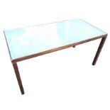 A contemporary rectangular table with drop-in opaque glass top in stained frame, raised on square