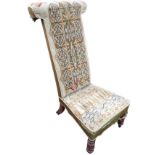 A Victorian rosewood prie dieu, the high back with cushioned rail having woolwork tapestry