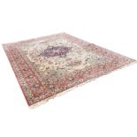 An oriental carpet woven with central blue scalloped medallion on ivory multi-floral field of linked