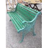A rectangular slatted garden bench with cast iron ends, the scrolled arms on pierced floral
