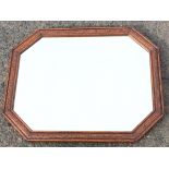 A rectangular octagonal oak framed mirror with bevelled plate in press carved ribbed channelled
