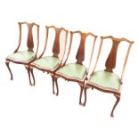 A set of four leather upholstered mahogany dining chairs, the backs inlaid with boxwood stringing