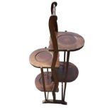 An Edwardian mahogany cakestand with turned handle on waved suppports, having four shaped rounded