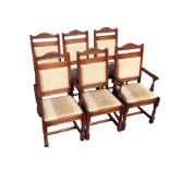 A set of six oak dining chairs with two carvers, the arched backs carved with floral medallions,