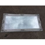 A large contemporary rectangular mirror, with bevelled plate in foliate moulded silvered frame