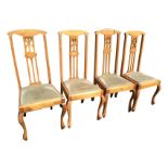 A set of four birch dining chairs with arched backs above pierced splats inlaid with oval shell