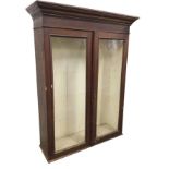 A nineteenth century stained glazed cupboard with moulded cornice above panelled doors enclosing a