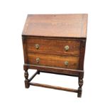 A 1930s oak bureau with cleated fallfront having mechanical lopers enclosing a fitted interior of