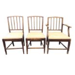 A set of three nineteenth century elm dining chairs with arched backs above square moulded spindles,