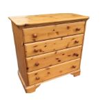 A reproduction pine chest of drawers with rectangular rounded top above four long knobbed drawers,