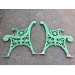 A pair of painted cast iron bench ends with scroll cast decoration to frames, the arms supported