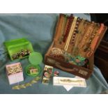 A case of costume jewellery with beads, necklaces, military buttons, brooches, a Timex watch, studs,